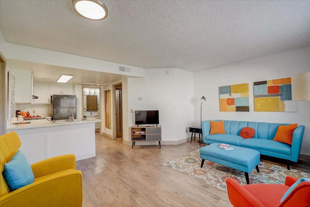 Living room seen over the kitchen counter, television and blue sofa