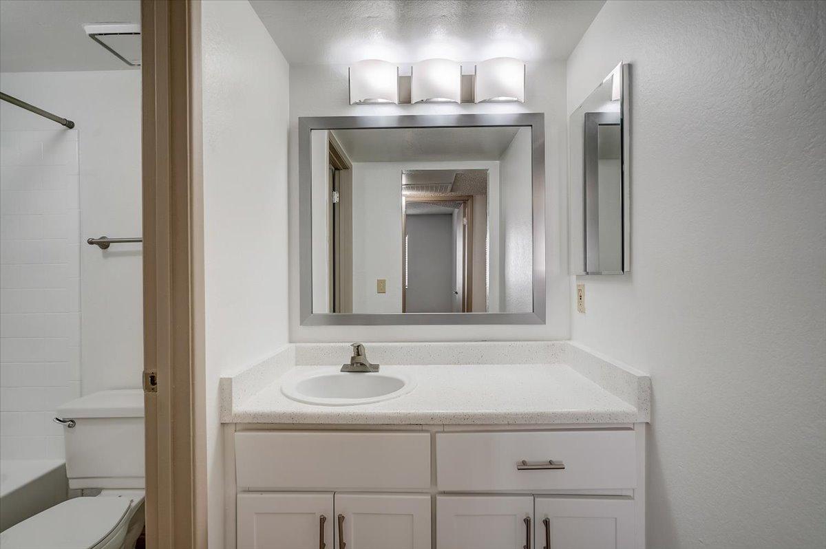 Vacant bathroom vanity, mirror and tub