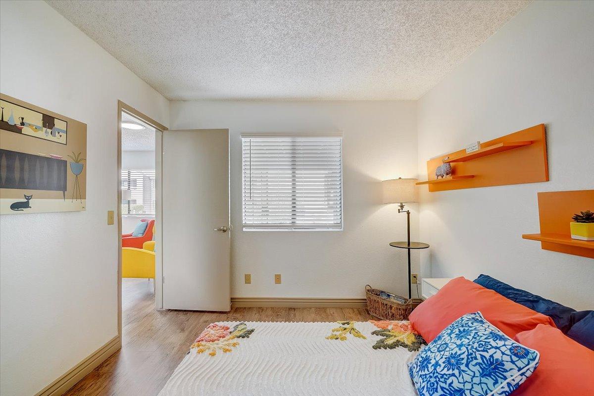 Primary bedroom with window and open door to the living room